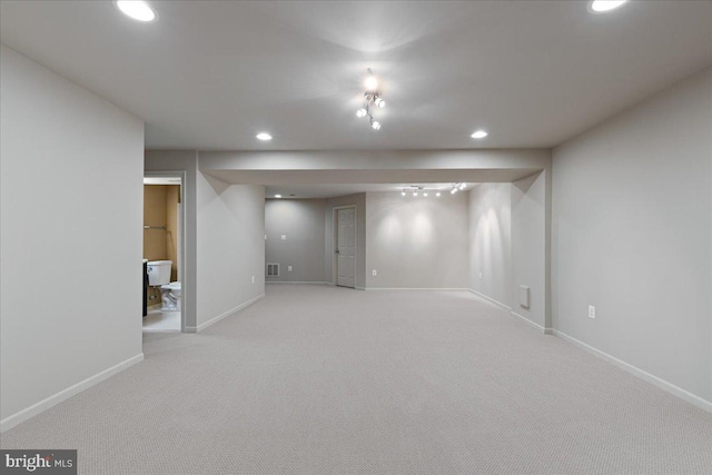 finished below grade area with visible vents, recessed lighting, light colored carpet, and baseboards