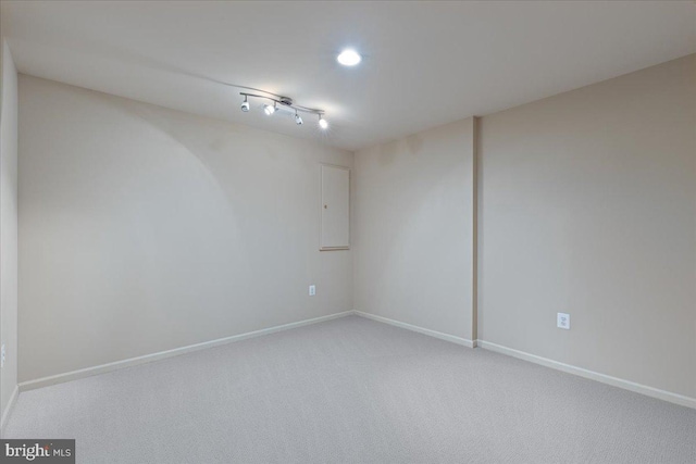 spare room with light carpet and baseboards