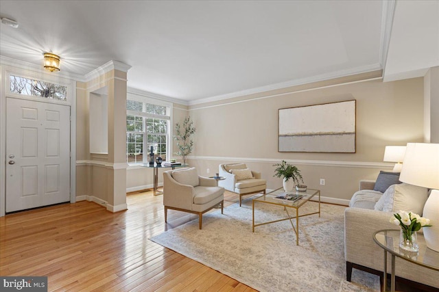 living area with crown molding, baseboards, and wood-type flooring