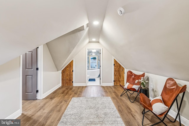 additional living space with lofted ceiling and light hardwood / wood-style flooring