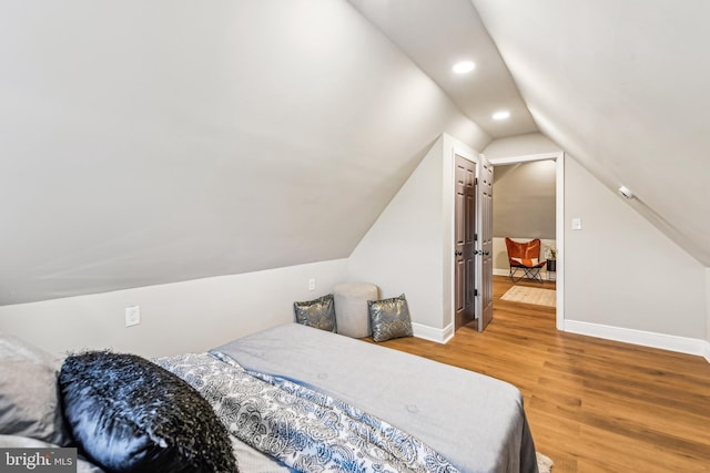 bedroom with vaulted ceiling and wood-type flooring