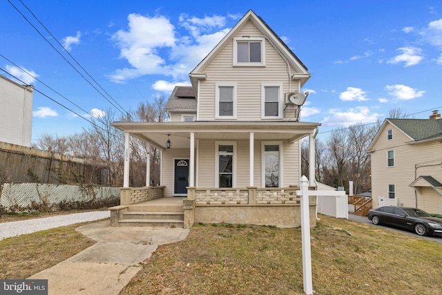 front of property featuring covered porch and a front lawn