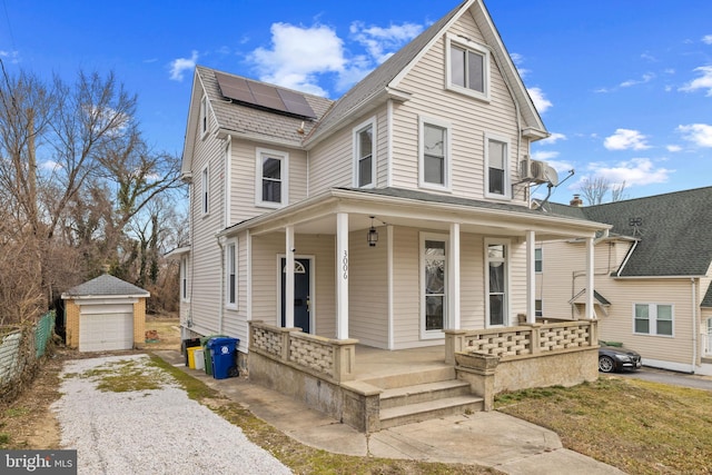 view of front facade with covered porch, a garage, an outdoor structure, and solar panels