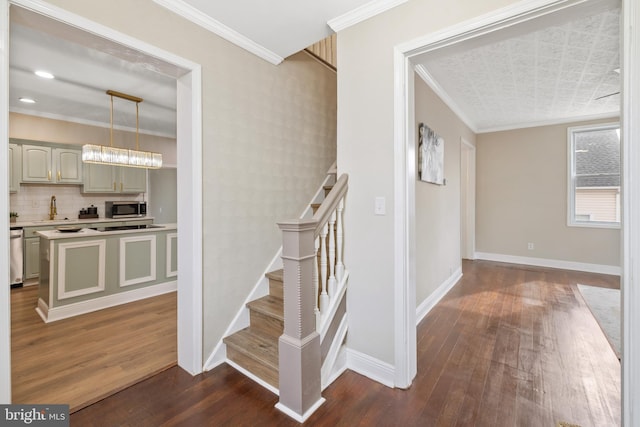 staircase with sink, ornamental molding, and hardwood / wood-style flooring