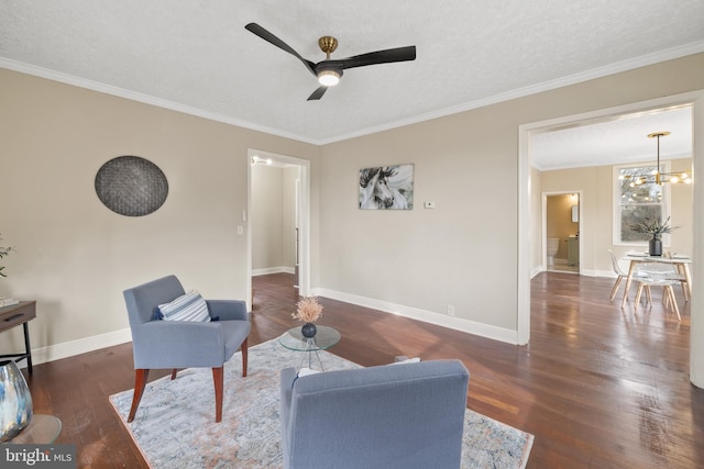 sitting room with ceiling fan with notable chandelier, a textured ceiling, dark hardwood / wood-style flooring, and ornamental molding