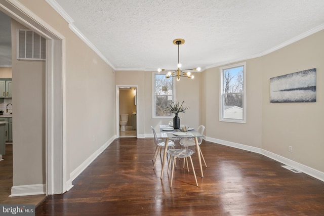 dining area featuring a notable chandelier, a textured ceiling, dark wood-type flooring, and ornamental molding