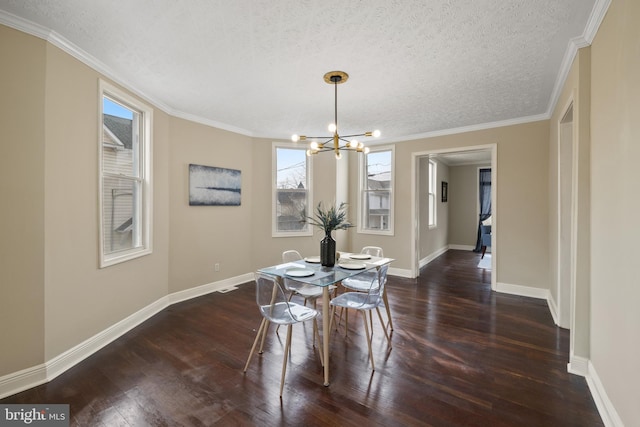 dining area featuring dark hardwood / wood-style flooring, a chandelier, crown molding, and a textured ceiling