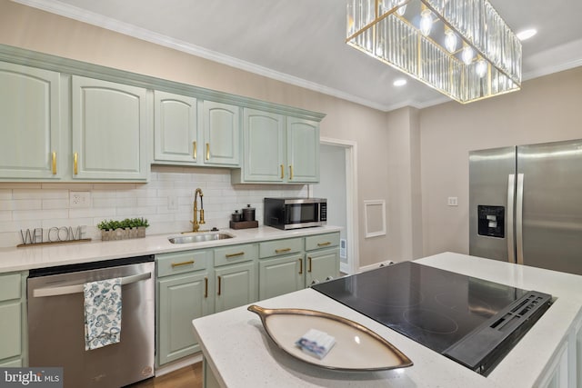 kitchen featuring hanging light fixtures, stainless steel appliances, sink, ornamental molding, and backsplash