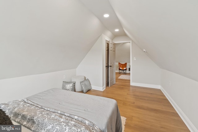 bedroom featuring hardwood / wood-style flooring and vaulted ceiling