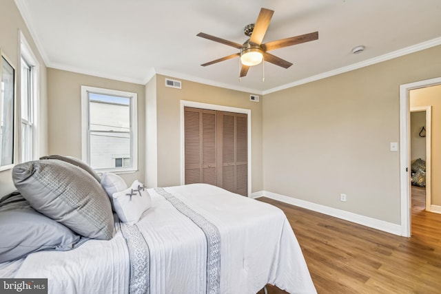 bedroom featuring ornamental molding, a closet, ceiling fan, and light hardwood / wood-style floors