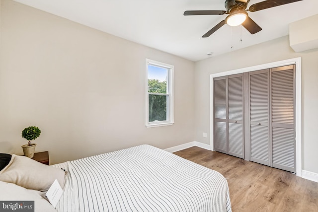 bedroom with ceiling fan, light hardwood / wood-style floors, and a closet