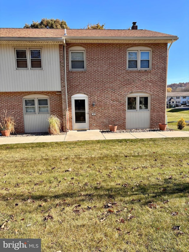 rear view of property with a yard