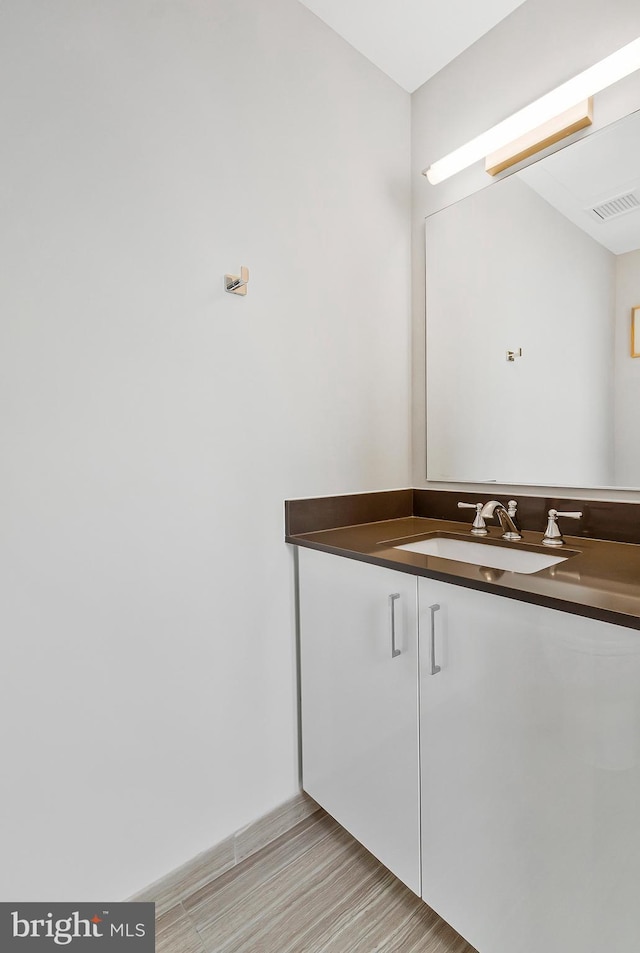 bathroom featuring visible vents, wood finished floors, and vanity