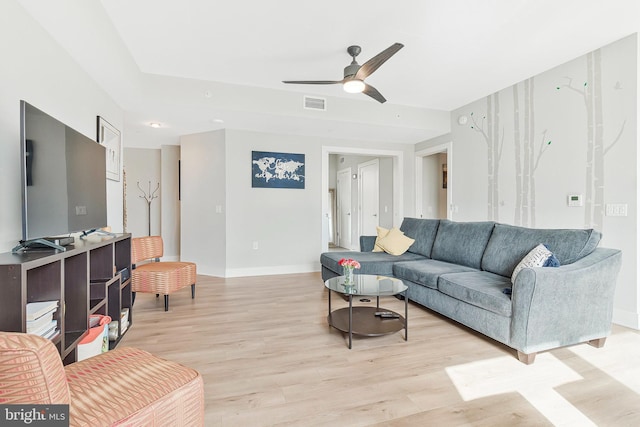 living room featuring light wood-style floors, ceiling fan, visible vents, and baseboards