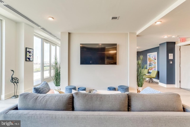 living room with visible vents, baseboards, and wood finished floors