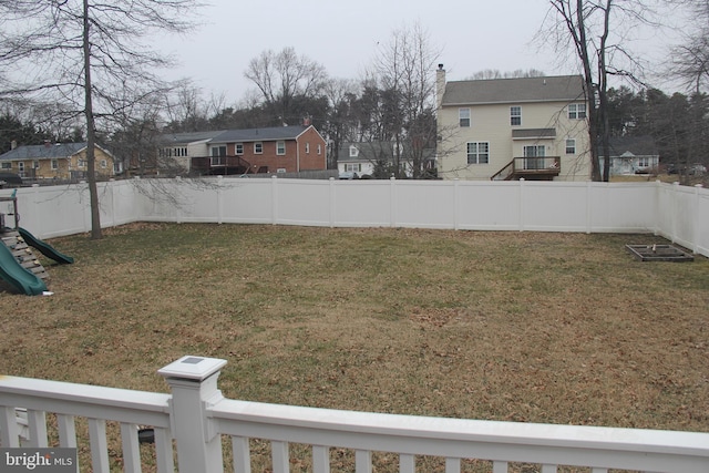 view of yard with a residential view, a fenced backyard, and a playground