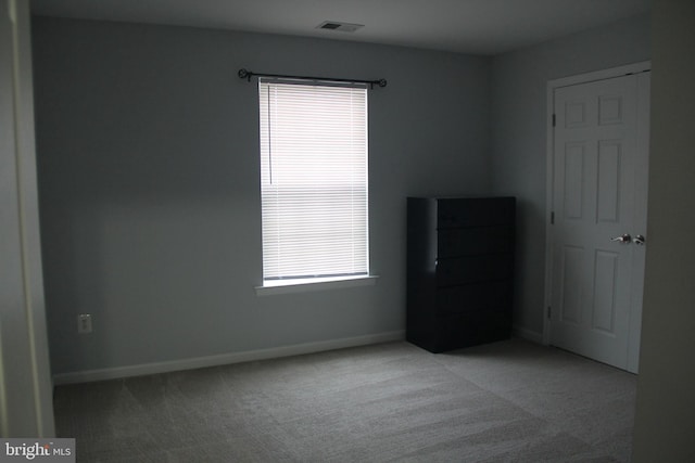 unfurnished bedroom featuring baseboards, visible vents, and light colored carpet