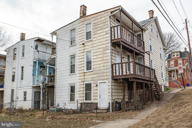 exterior space featuring a chimney and a balcony