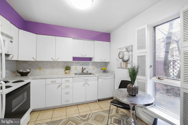 kitchen with white appliances, light tile patterned floors, light countertops, and a sink