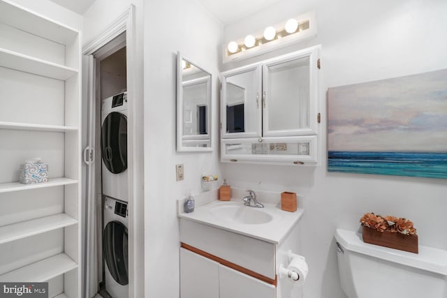 bathroom featuring vanity, toilet, and stacked washer / drying machine