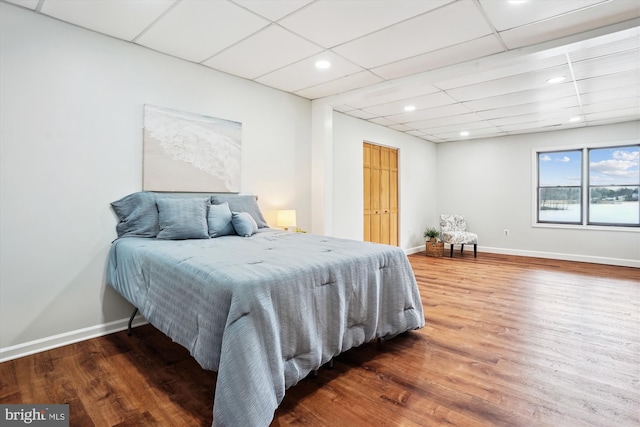 bedroom featuring hardwood / wood-style floors and a paneled ceiling