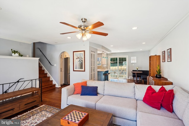 living area with arched walkways, a ceiling fan, wood finished floors, stairs, and recessed lighting