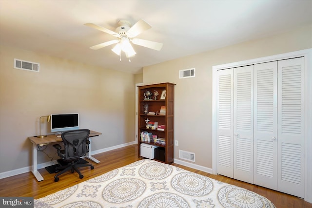 office area with baseboards, visible vents, and wood finished floors