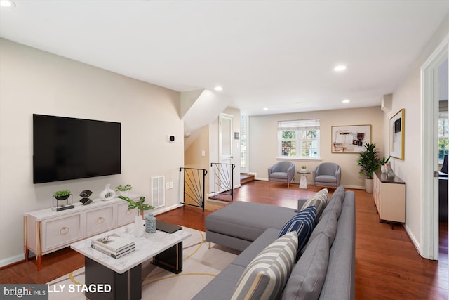 living room with baseboards, visible vents, wood finished floors, and recessed lighting