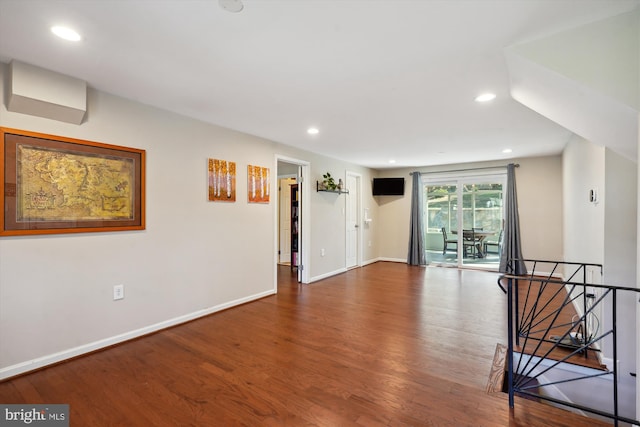 unfurnished room featuring baseboards, wood finished floors, and recessed lighting