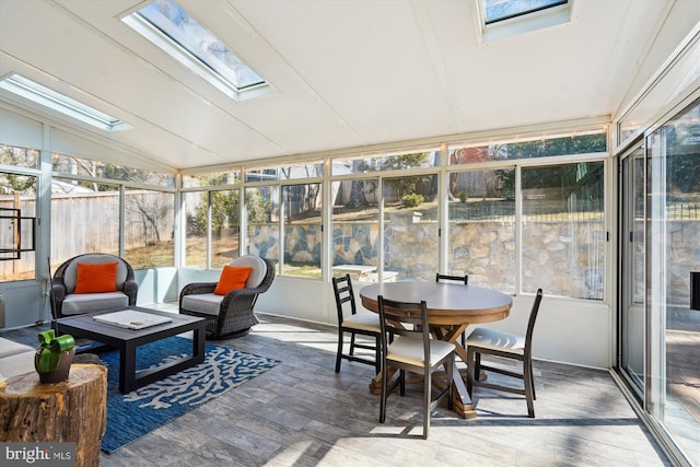 sunroom featuring lofted ceiling with skylight