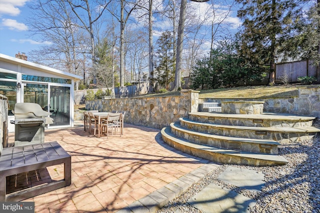 view of patio featuring fence, outdoor dining area, and area for grilling