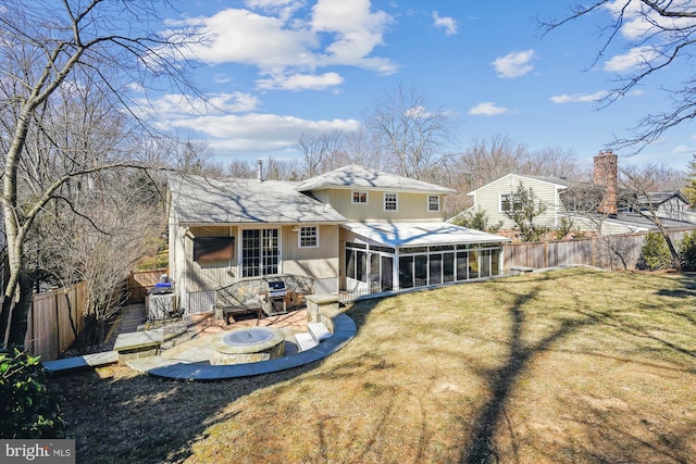 back of property featuring a fenced backyard, a fire pit, a sunroom, a lawn, and a patio area