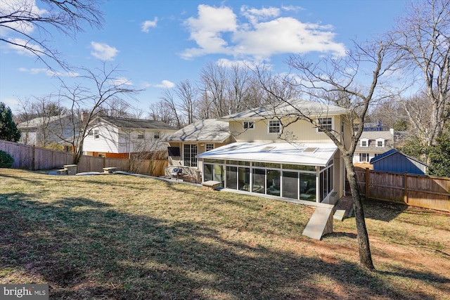 back of house with a sunroom, a fenced backyard, and a yard