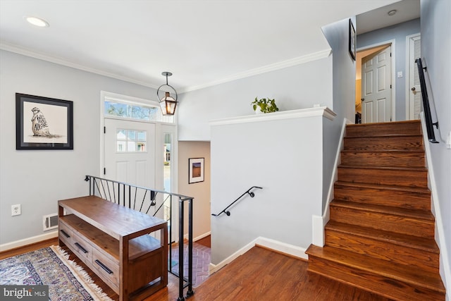 entrance foyer with crown molding, baseboards, and wood finished floors