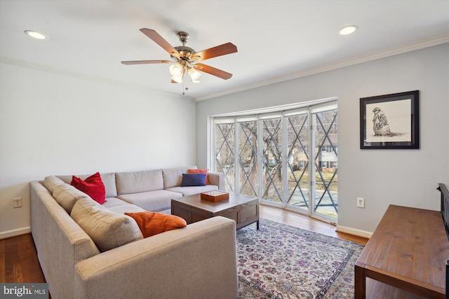 living room with a ceiling fan, baseboards, ornamental molding, and wood finished floors