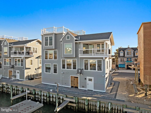 rear view of property featuring a water view and a balcony