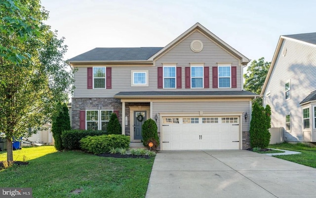 traditional home with stone siding, a front lawn, an attached garage, and driveway