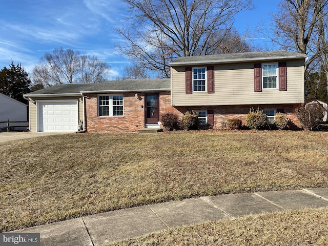 split level home featuring a garage, concrete driveway, brick siding, and a front yard