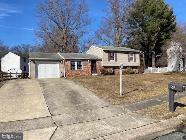 tri-level home featuring a garage and a front lawn