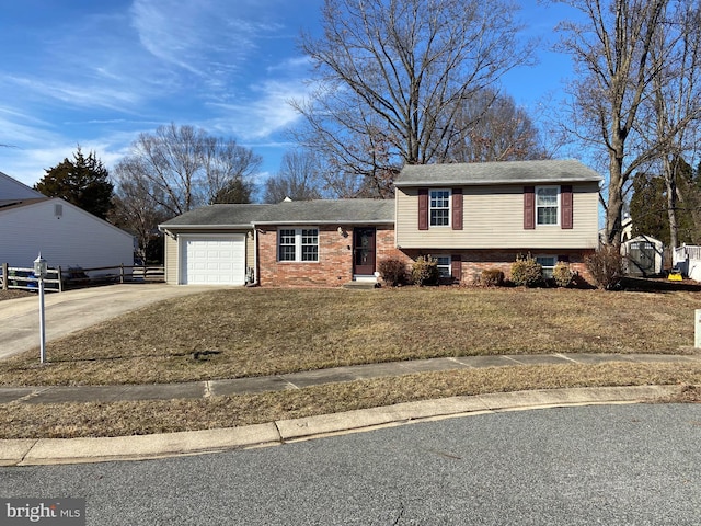 split level home with a garage, a front yard, brick siding, and driveway