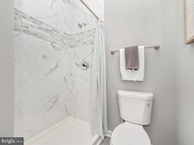 bathroom featuring curtained shower and toilet