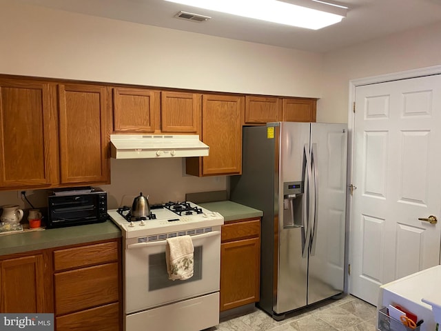 kitchen with stainless steel refrigerator with ice dispenser and white range with gas stovetop