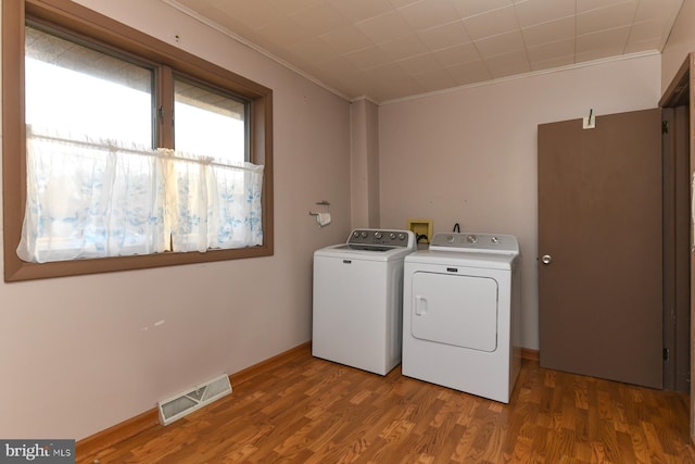 laundry room featuring crown molding, wood-type flooring, and washer and clothes dryer