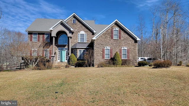 traditional home featuring a front yard and stone siding