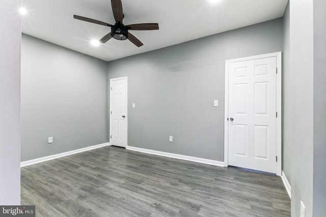 spare room featuring a ceiling fan, baseboards, and wood finished floors