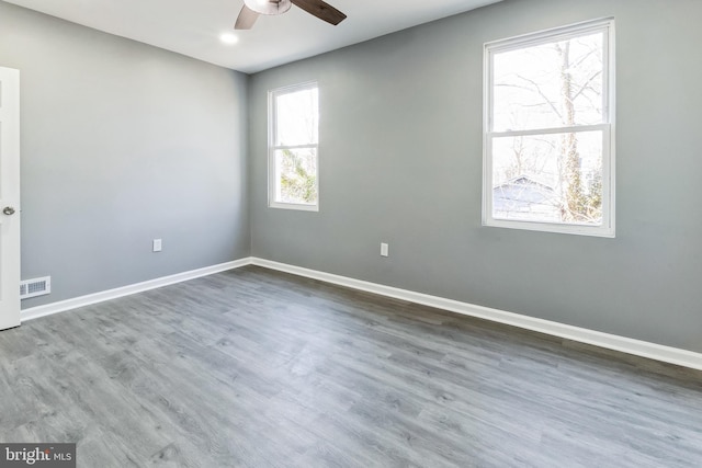 empty room featuring visible vents, baseboards, ceiling fan, and wood finished floors