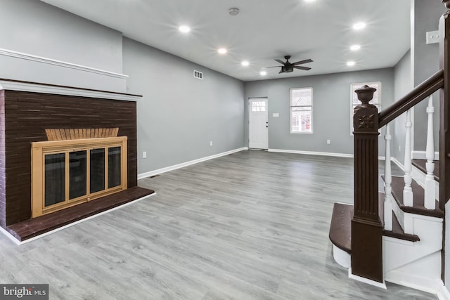 unfurnished living room featuring baseboards, visible vents, wood finished floors, stairs, and recessed lighting