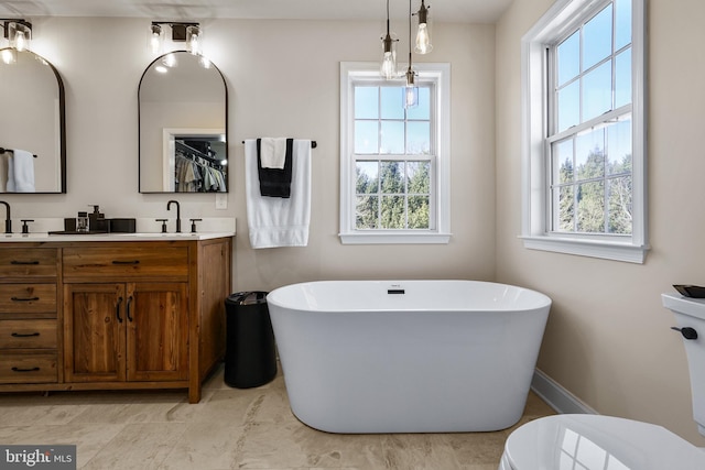 bathroom with vanity, plenty of natural light, and a bath