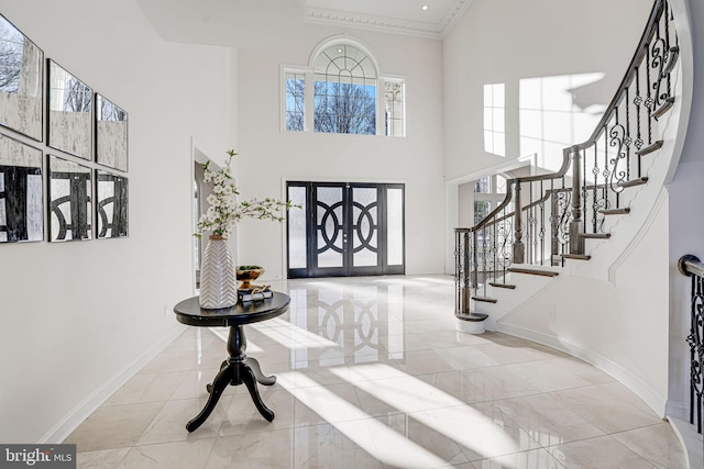 entryway with crown molding and a high ceiling