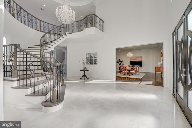 foyer entrance featuring a towering ceiling and a notable chandelier